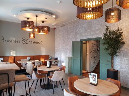 a restaurant with tables and chairs and chandeliers at Slapen Bij Brownies & Downies in Valkenswaard