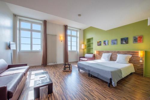 a large bedroom with a bed and a couch at Résidence Villemanzy in Lyon