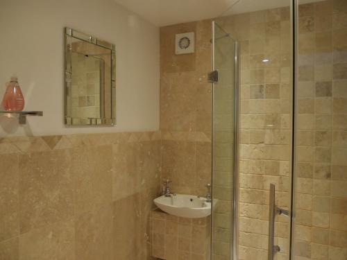a bathroom with a sink and a glass shower at Garden Bank Cottage in Kelso