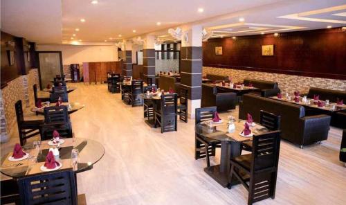 a restaurant with tables and chairs in a room at Hotel Lake Shilloi in Dimāpur