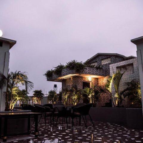 a patio with tables and chairs in front of a building at Hotel Lake Shilloi in Dimāpur