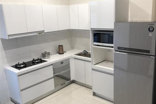 a white kitchen with a stove and a refrigerator at Chiang Mi No.1 B&B in Chaozhou