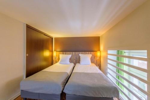 a pair of beds in a room with a window at Résidence Villemanzy in Lyon