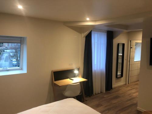 a bedroom with a bed and a desk and a window at Mayrena Hotel Restaurant - Destination Le Tréport Mers in Eu