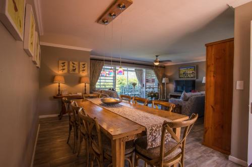 cocina y comedor con mesa de madera y sillas en dk villas 1 Harbour View Hout Bay, en Hout Bay