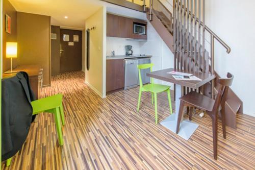 a living room with a table and chairs and a kitchen at Résidence Villemanzy in Lyon