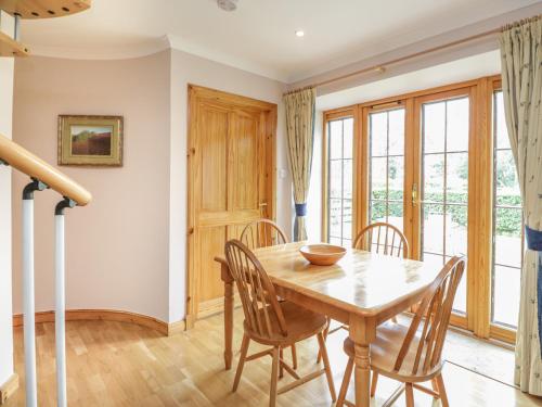 a dining room with a wooden table and chairs at Kamba Cottage in Tannadice