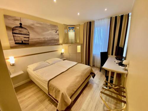 una camera con letto, tavolo e scrivania di Park Hotel Hamburg Arena ad Amburgo