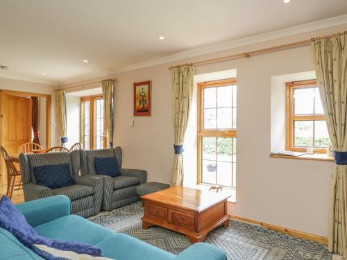a living room with two couches and a coffee table at Kamba Cottage in Tannadice