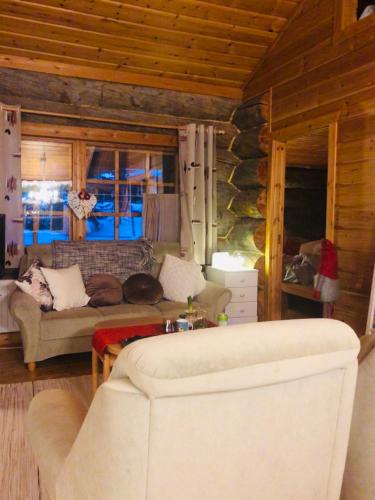 a living room with a couch and a table at Villa Karhuntähti in Luosto