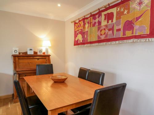 a dining room with a wooden table and chairs at Nantusi Cottage in Tannadice