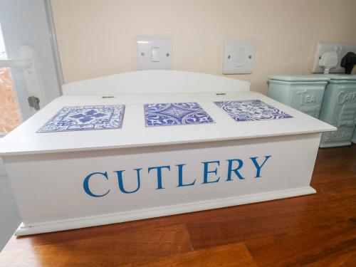 a bed in a room with a quilty sign on it at Merlin's Retreat in Tintagel