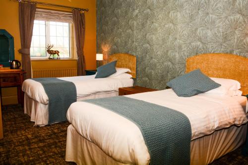 a hotel room with two beds and a window at Plough Inn in Morpeth
