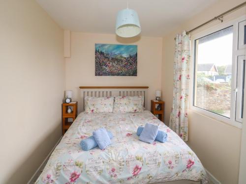 a bedroom with a bed with two blue pillows at Merlin's Retreat in Tintagel