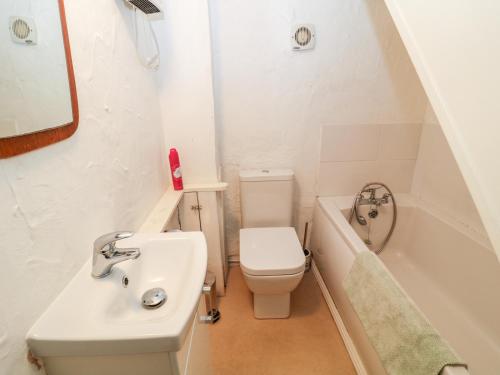 a bathroom with a sink and a toilet and a tub at Treverbyn Smithy in Saint Neot