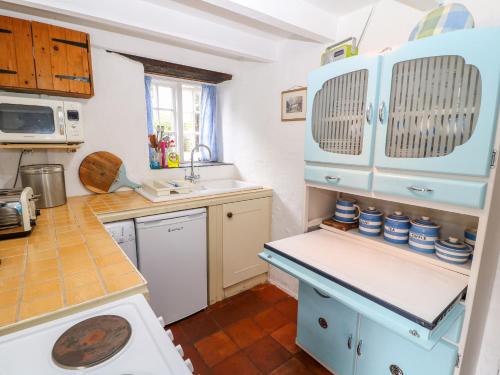 a kitchen with blue cabinets and a counter top at Treverbyn Smithy in Saint Neot