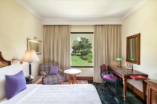 Habitación de hotel con cama y escritorio en Trident Udaipur en Udaipur