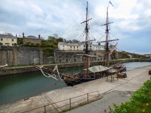 a tall ship is docked in the water at The Mackerel in Charlestown