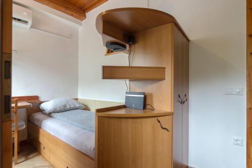 1 dormitorio pequeño con 1 cama y armario de madera en Cozy, Bright and Affordable Single Studio - Free Parking, en Liubliana