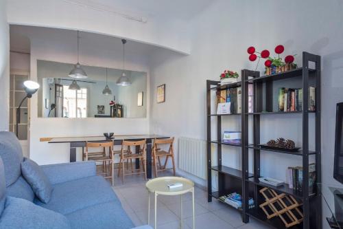 a living room with a blue couch and a table at Apartamento Sant Gervasi in Barcelona