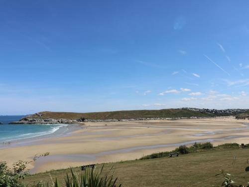 a beach with people sitting on the sand and the ocean at Honeycrock in Cubert