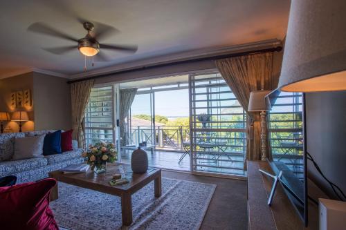 a living room with a couch and a table at dk villas 1 Harbour View Hout Bay in Hout Bay
