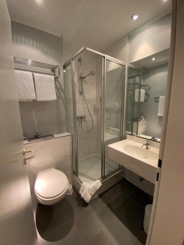 a bathroom with a shower and a toilet and a sink at Park Hotel Hamburg Arena in Hamburg