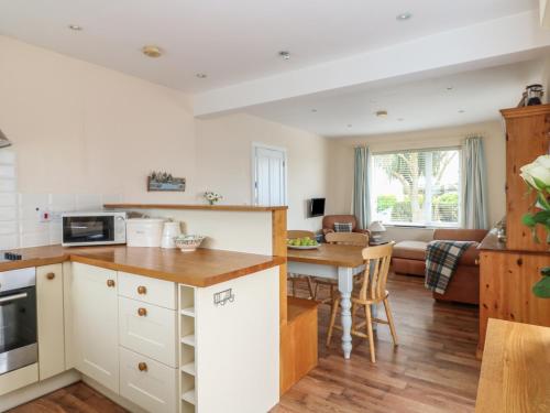 a kitchen and living room with a table and a couch at Bolenowe in Polzeath