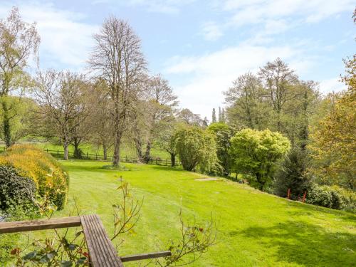 a park with a bench in a green field at Old Ford Farm Annexe in Widworthy