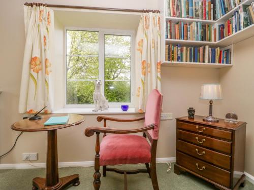 a desk and chair in a room with a window at Old Ford Farm Annexe in Widworthy