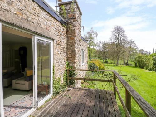 a wooden ramp leading to a brick building with a porch at Old Ford Farm Annexe in Widworthy
