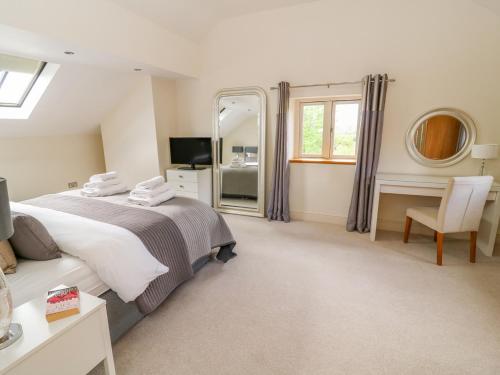 1 dormitorio con 1 cama grande y espejo en Cottam Cottage Farm, en Longridge