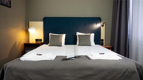 a bedroom with a large bed with two towels on it at First Hotel Central in Norrköping