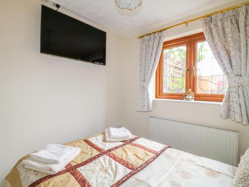 a bedroom with a bed with a tv on the wall at Bramble Grange in Overseal