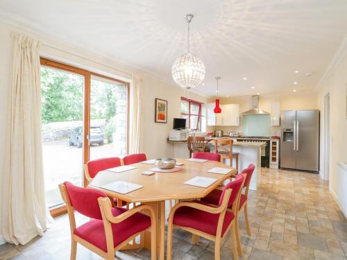 una cucina e una sala da pranzo con tavolo e sedie di Woodland Villa a Oban