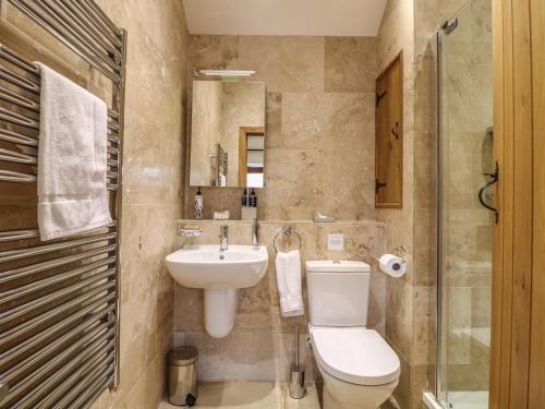 a bathroom with a toilet and a sink at The Cow Shed in Stanton in Peak