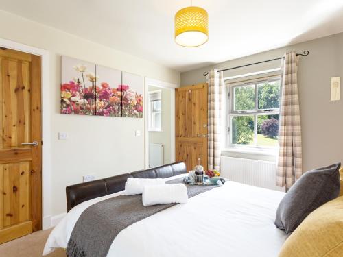 a bedroom with a bed and a window at 1 Springwater View in Mickleton