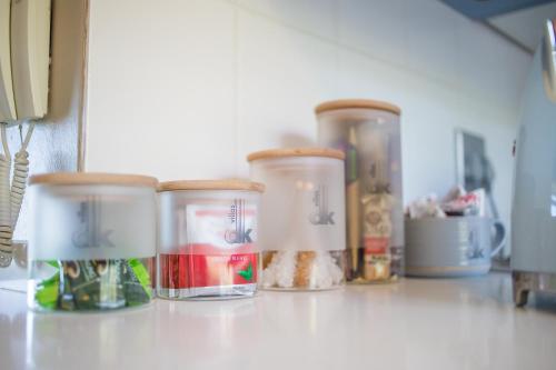 a counter with four glass containers on a counter top at dk villas 1 Harbour View Hout Bay in Hout Bay