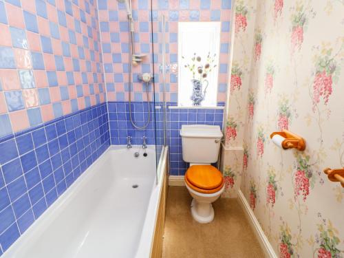 a bathroom with a tub and a toilet with a toilet seat at Barnbrook in Carperby