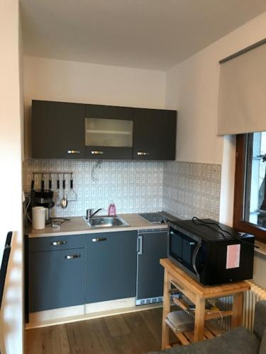 a kitchen with blue cabinets and a microwave on a table at Landhaus Zirben in Bad Kleinkirchheim