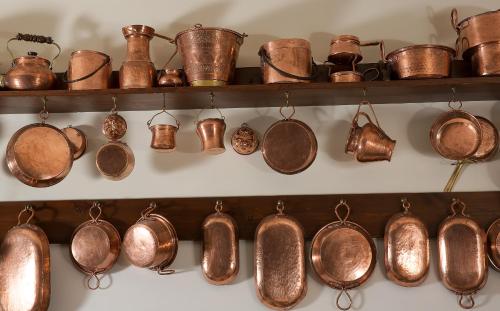 a bunch of copper pots and pans on a shelf at Hotel & Spa Bellavista Francischiello in Massa Lubrense