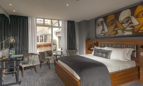 a hotel room with a bed and a table and chairs at Oriel House Hotel in Cork