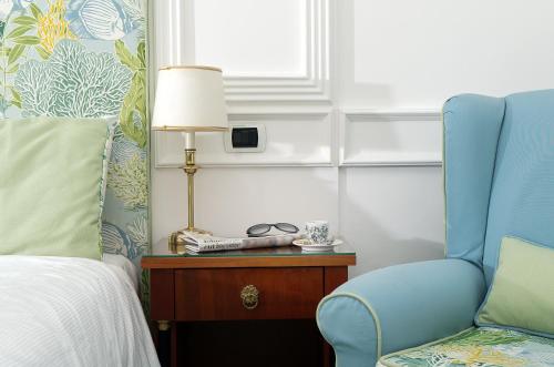 a bedroom with a bed and a blue chair at Hotel & Spa Bellavista Francischiello in Massa Lubrense