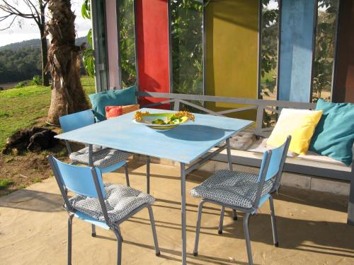 une table et des chaises bleues avec un bol de fruits. dans l'établissement Bel Appart Style Vintage Vue Mer, à La Londe-les-Maures