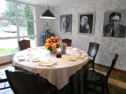 a dining room table with a white tablecloth and flowers on it at Segovia Sierra de Guadarrama in Los Ángeles de San Rafael