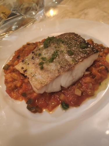 a piece of fish sitting on a plate of food at Segovia Sierra de Guadarrama in Los Ángeles de San Rafael
