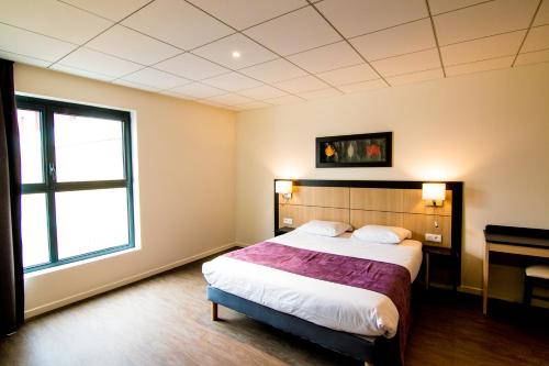een slaapkamer met een groot bed en een raam bij Tulip Inn Thionville Residences in Thionville
