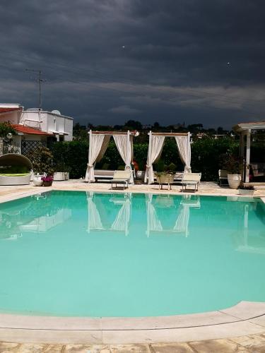 a large blue pool with chairs at Agriturismo Salinola in Ostuni
