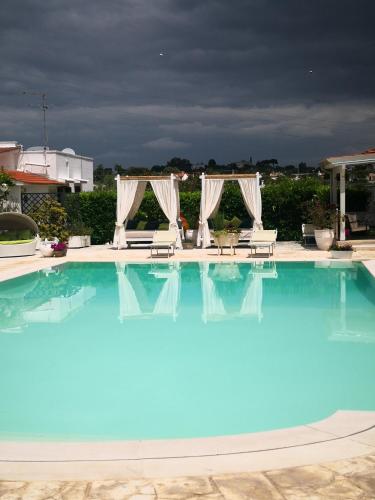 a large swimming pool with blue water in a resort at Agriturismo Salinola in Ostuni