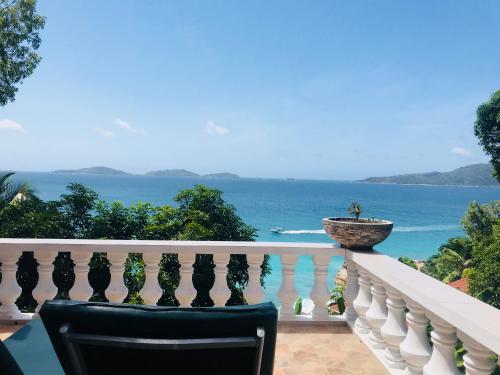 una silla en el balcón con vistas al océano en Patatran Village Hotel, en La Digue